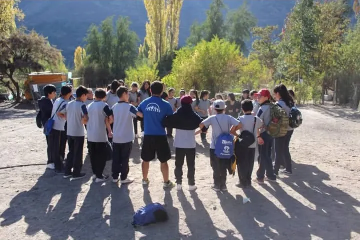 Estudiantes de un curso reunidos en círculo antes de una caminata