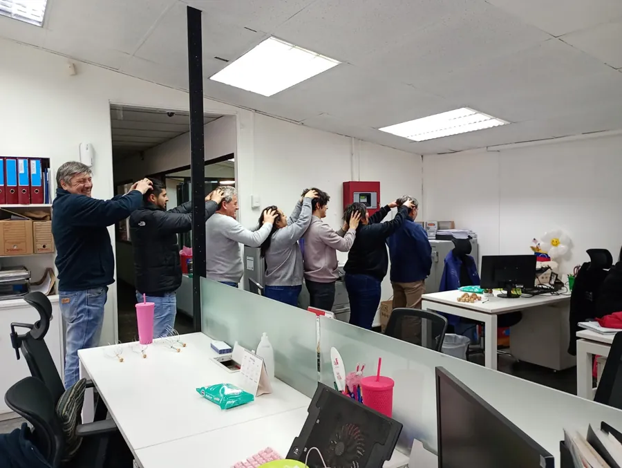 Equipo de oficina haciendo ejercicios de pausa activa junto a sus escritorios